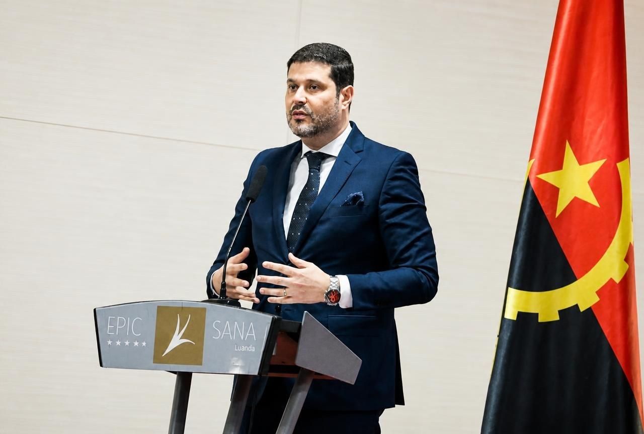 João Rosa, cofundador e CEO da Angola Global Hub, a discursar num evento em Luanda junto à bandeira de Angola